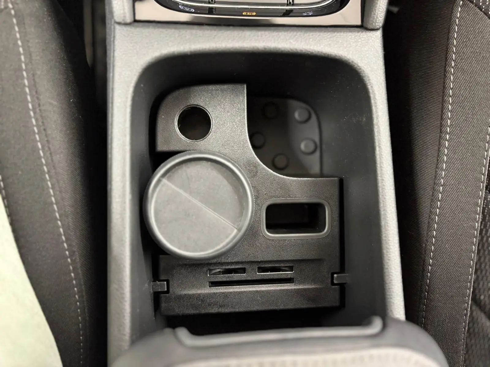 Gros plan sur le rangement central noir entre les sièges avant du Skoda Kodiaq blanc Lune 2022.