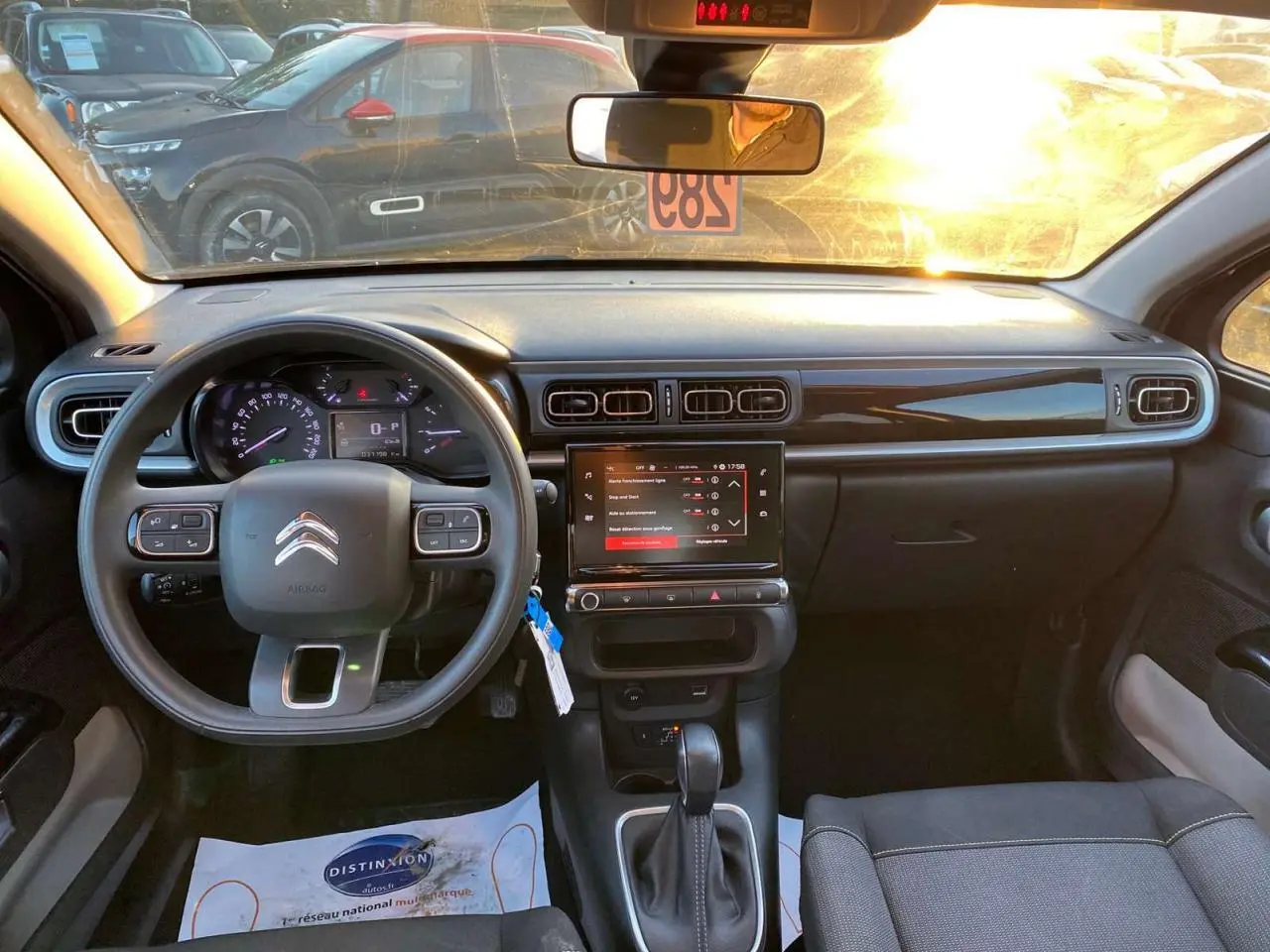 Intérieur de la Citroën C3 Shine 2023 vu de face, tableau de bord noir avec écran tactile et volant multifonction.