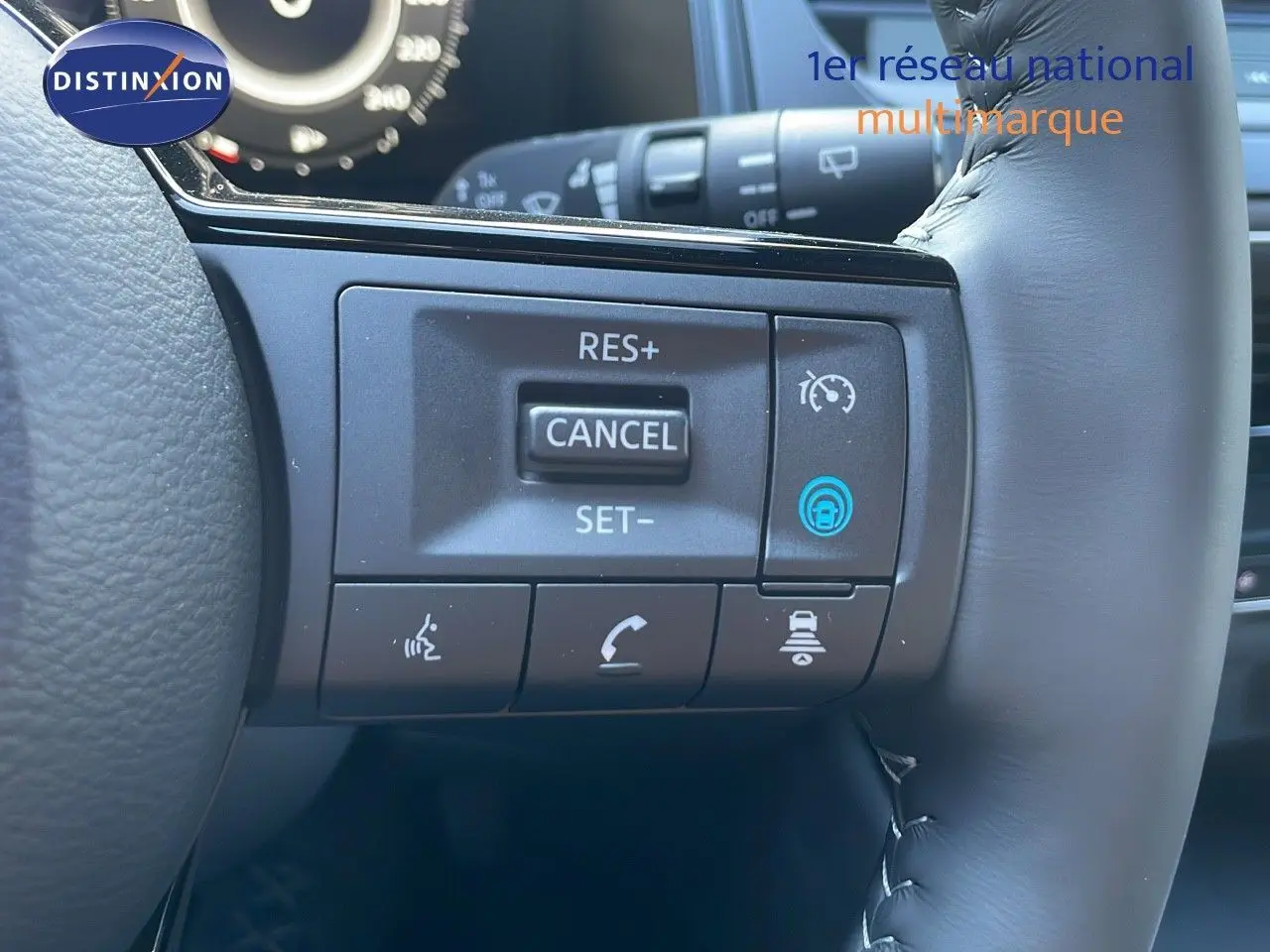 Gros plan sur les commandes au volant du Nissan Qashqai 2025 gris céramique avec toit noir, mettant en avant les boutons de régulateur de vitesse.