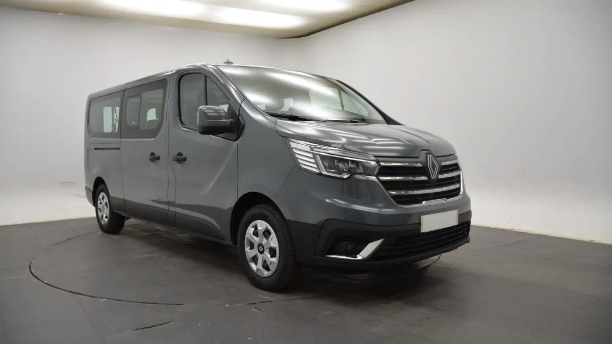 Renault Trafic Fourgon gris clair vu en 3/4 avant droit, avec calandre chromée et feux LED distinctifs.