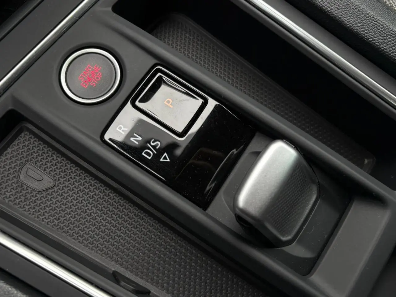 Gros plan sur la commande de boîte automatique et bouton start/stop dans l’habitacle noir du SEAT Leon 2024.