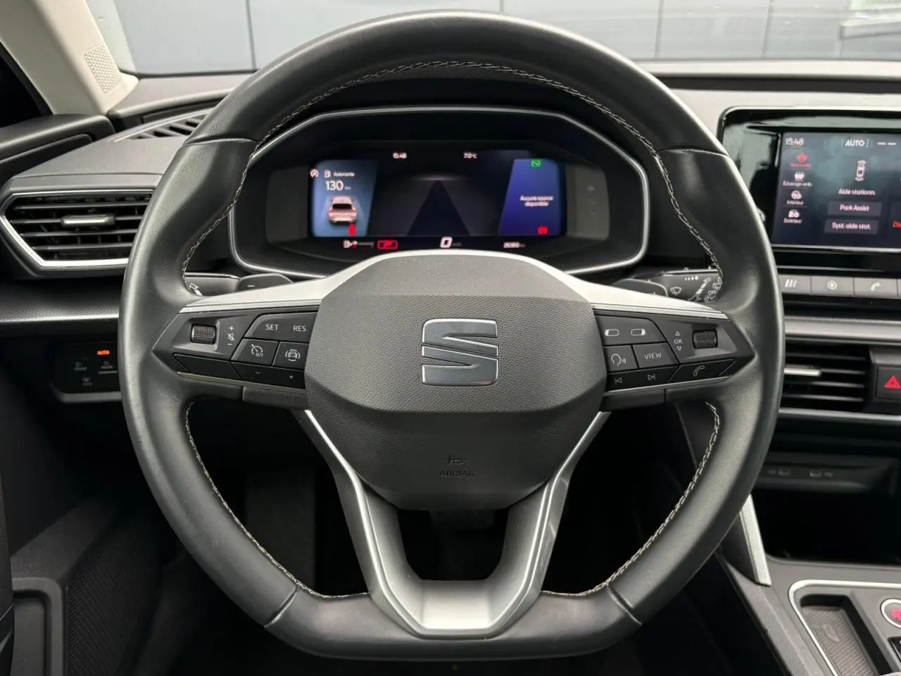 Vue rapprochée du volant cuir multifonction de la SEAT LEON 2024 avec tableau de bord digital et écran central tactile.