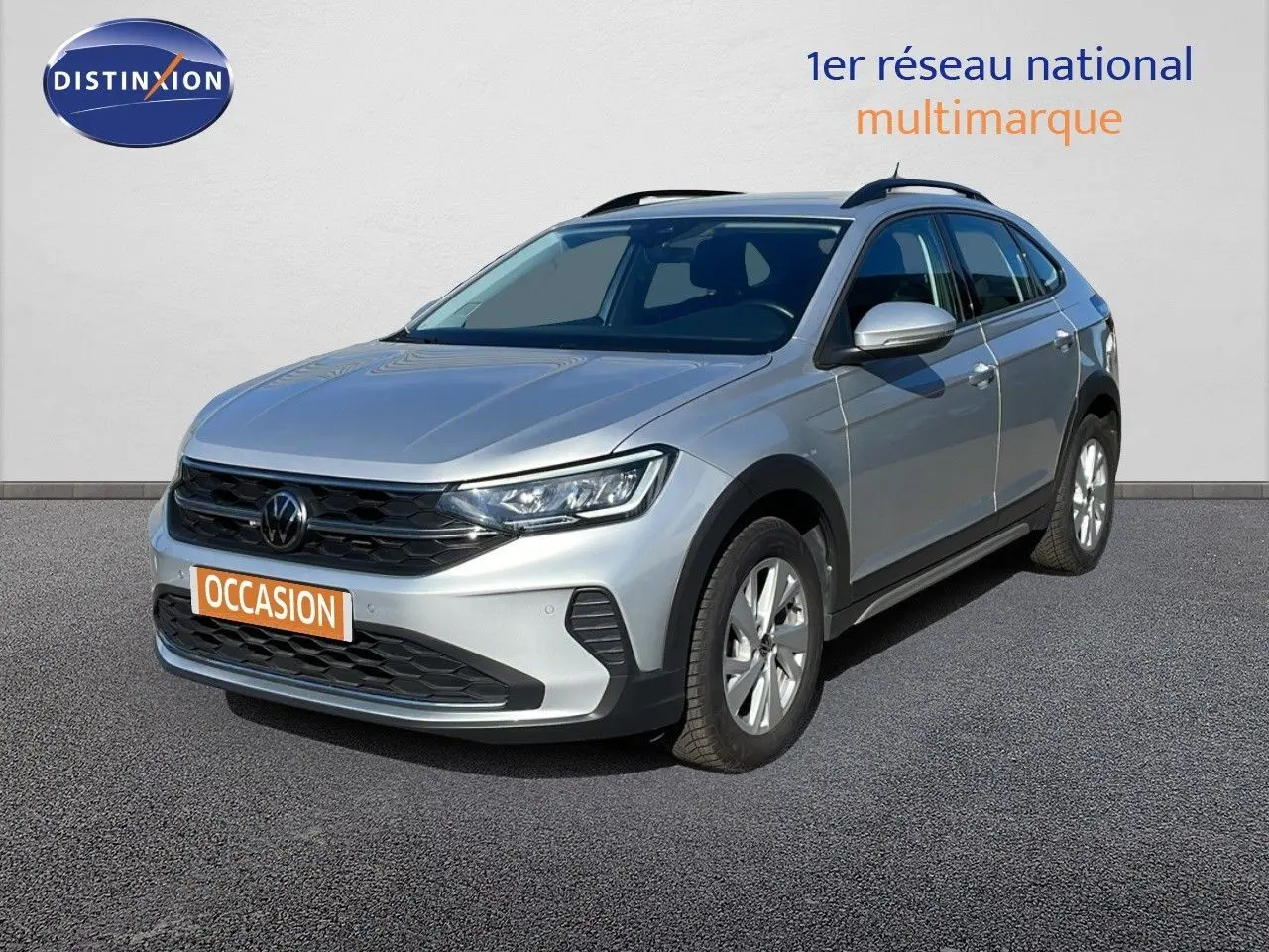 Volkswagen Taigo 1.0 TSI 110ch Life Business en reflet d'argent métal, vue 3/4 avant droit sur sol gris.