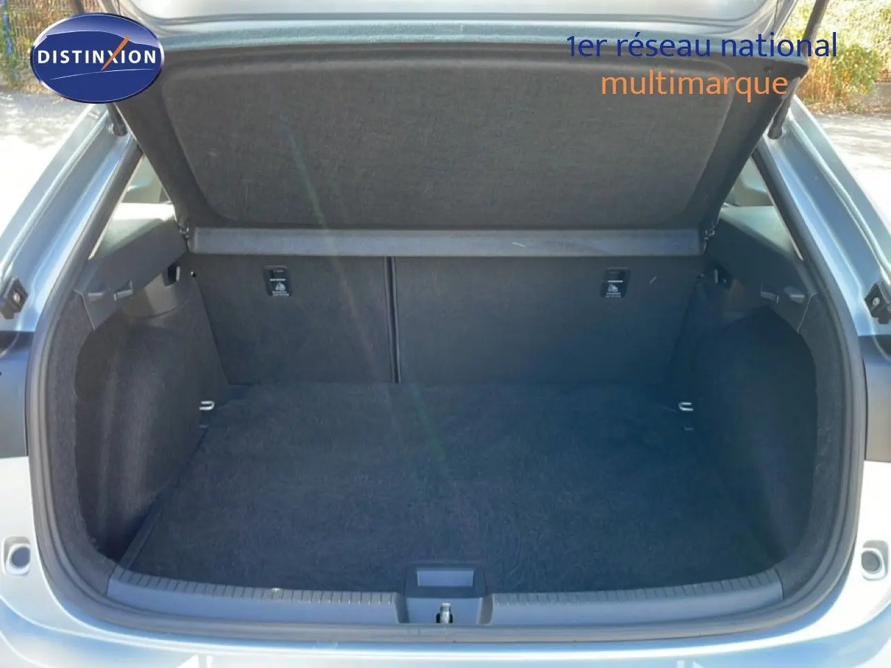 Coffre ouvert vu de l'arrière d'un Volkswagen Taigo 2022 couleur reflet d'argent métal, espace de chargement vide et propre.