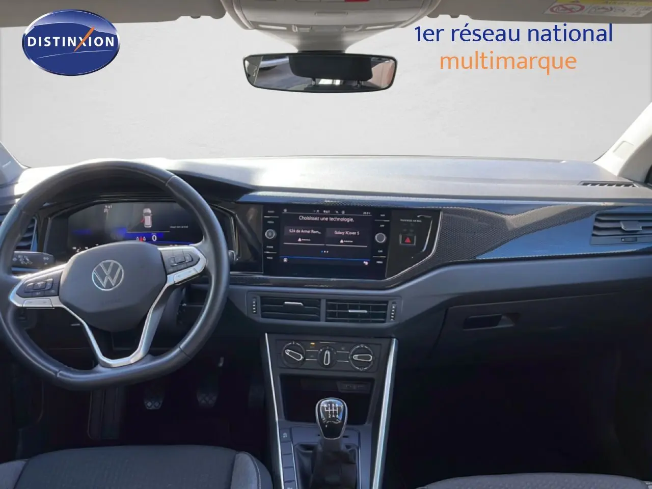 Vue intérieure du tableau de bord et volant noir du Volkswagen Taigo 2022, avec écran tactile et boîte manuelle.