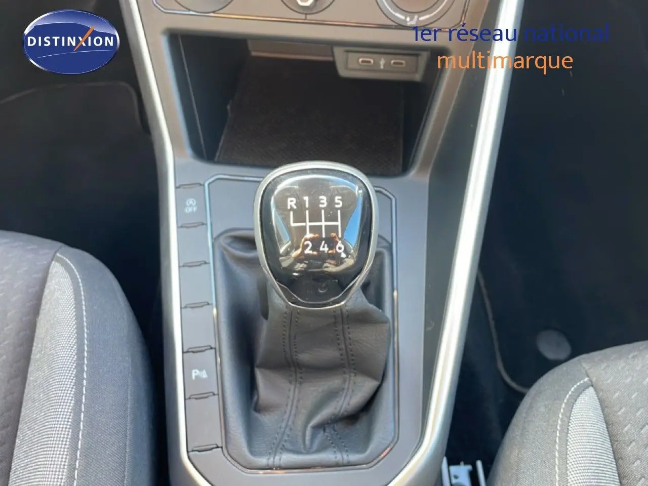 Gros plan sur le levier de vitesses manuel du Volkswagen Taigo 2022 couleur reflet d'argent métal, intérieur tissu gris.