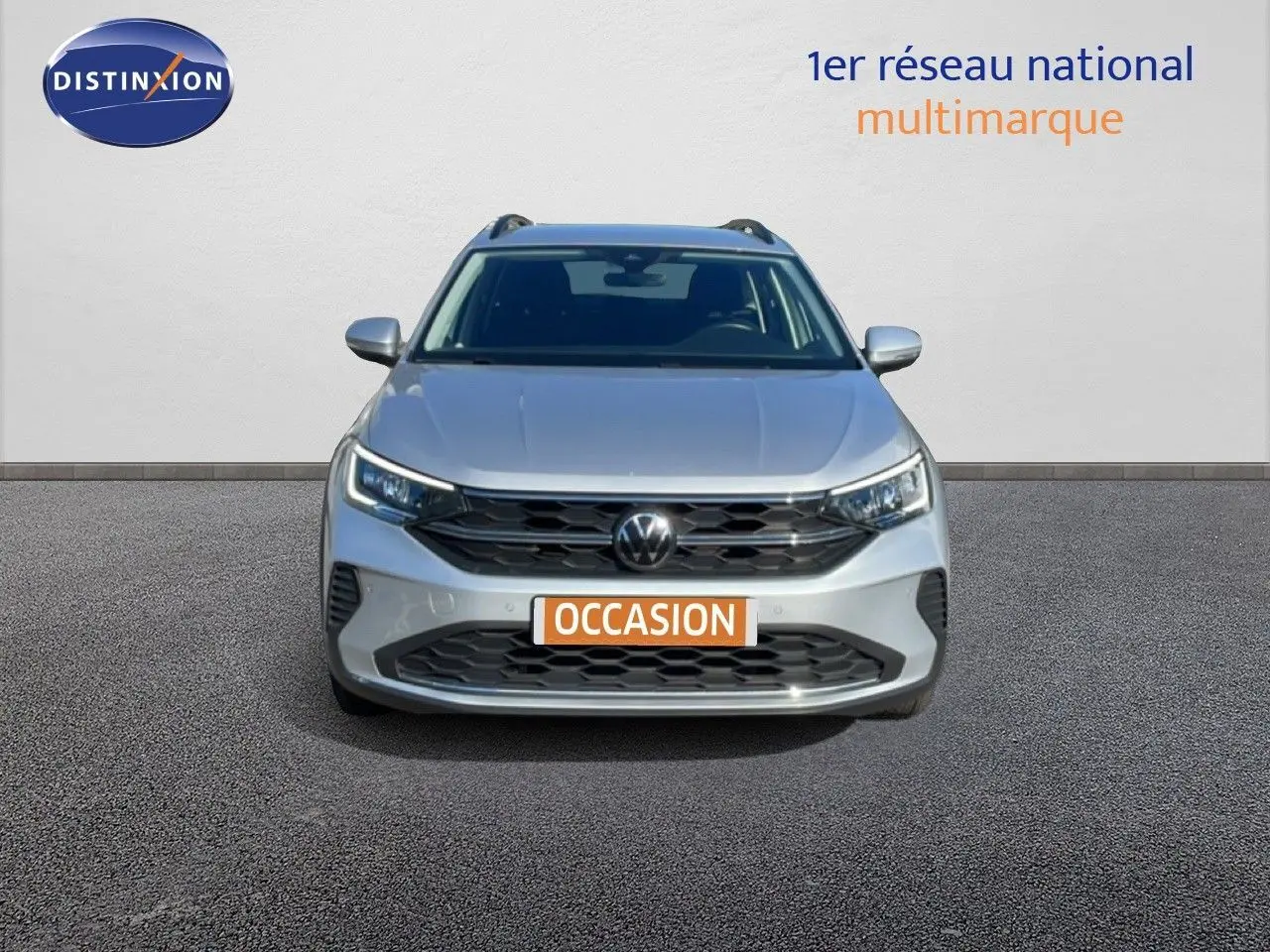 Vue frontale d'un Volkswagen Taigo 1.0 TSI 110ch Life Business en reflet d'argent métal avec calandre noire et feux LED.