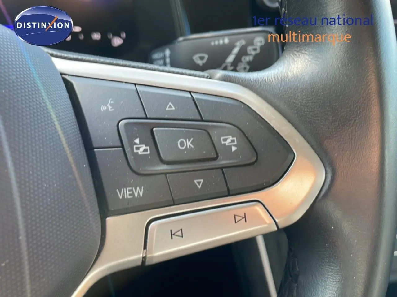 Gros plan sur les commandes multifonctions à gauche du volant en cuir noir du Volkswagen Taigo 2022.