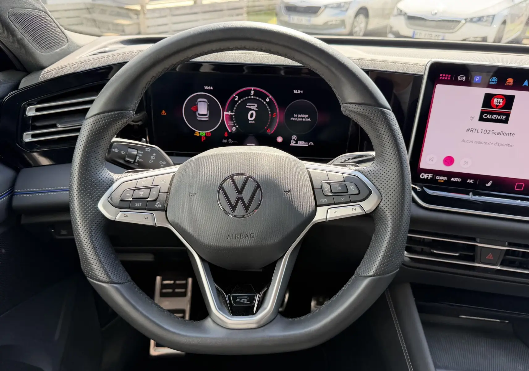 Vue intérieure centrée sur le volant cuir multifonction du Volkswagen Tiguan 2025 avec écran digital et console tactile.