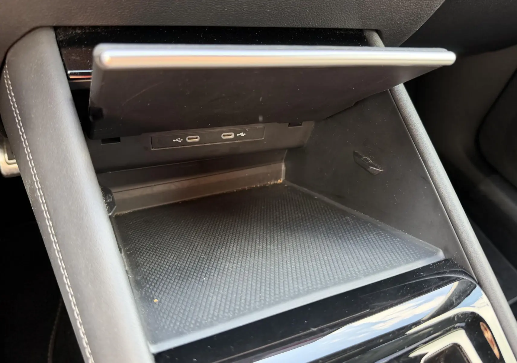 Gros plan sur la console centrale noire du Volkswagen Tiguan 2025, montrant un compartiment ouvert avec deux ports USB-C.