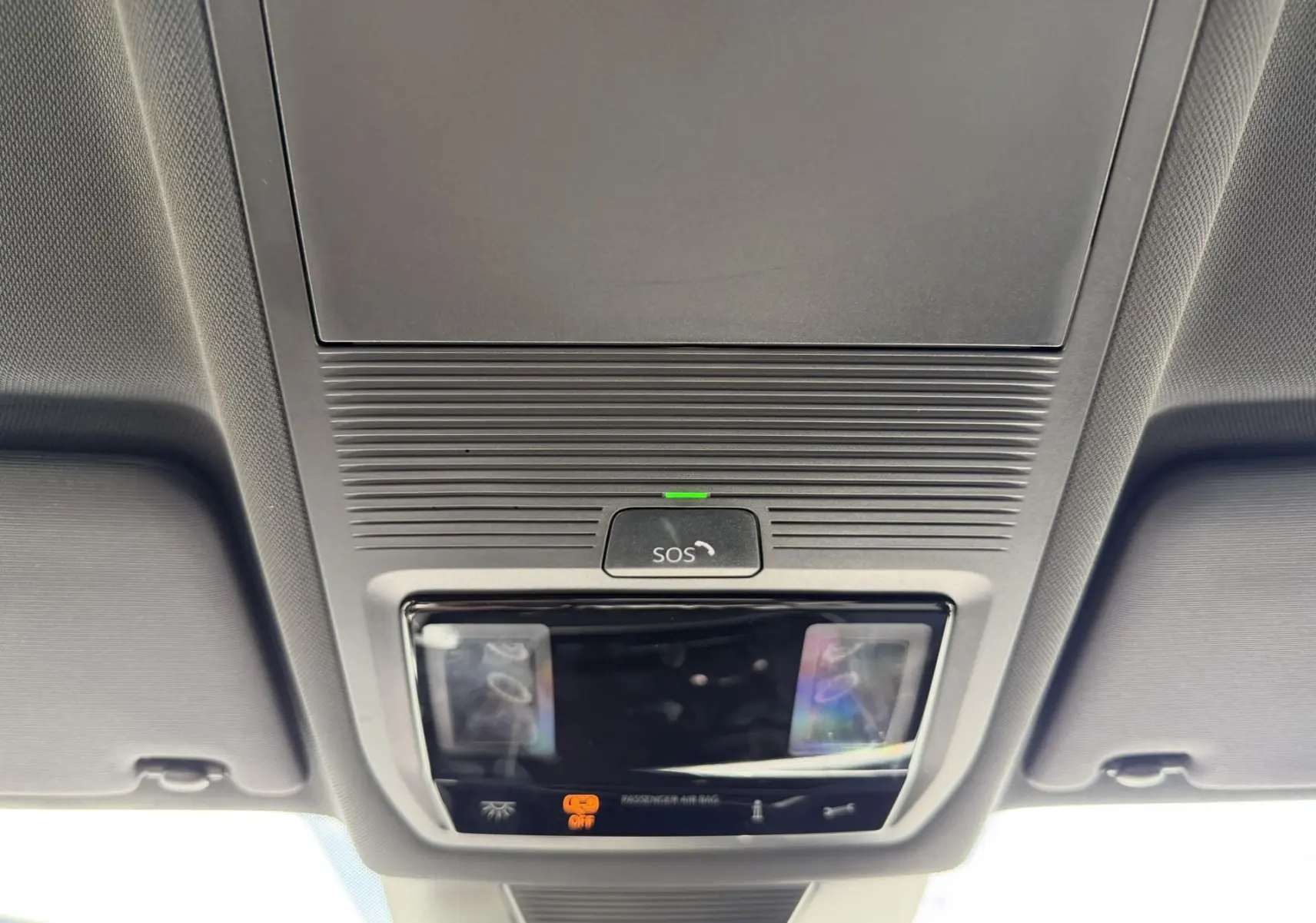 Vue en plongée sur le plafonnier gris avec bouton SOS et éclairages intérieurs du Volkswagen Tiguan noir 2025.