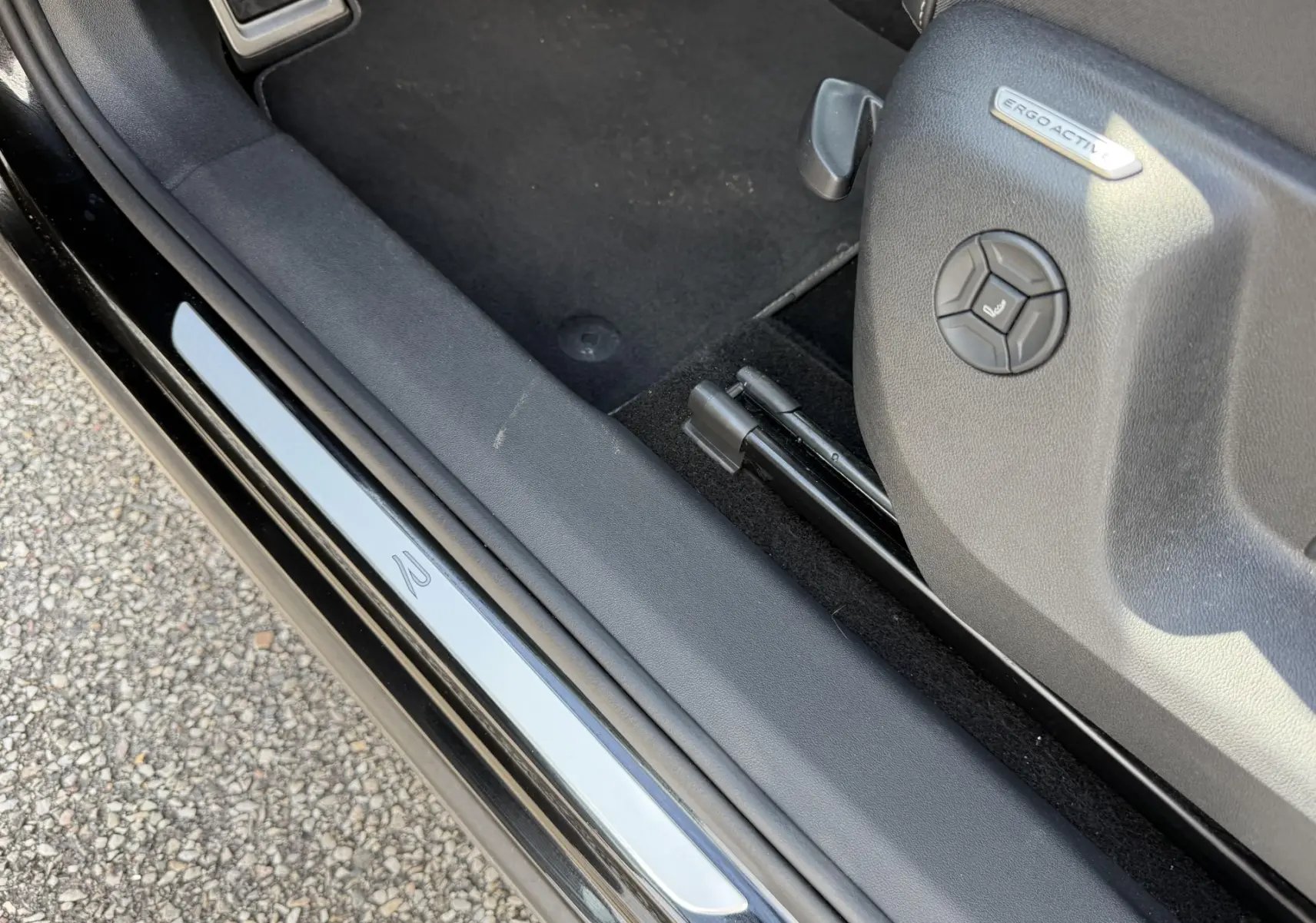 Détail de la porte côté conducteur du Volkswagen Tiguan noir 2025 avec seuil de porte R et siège ErgoActive.