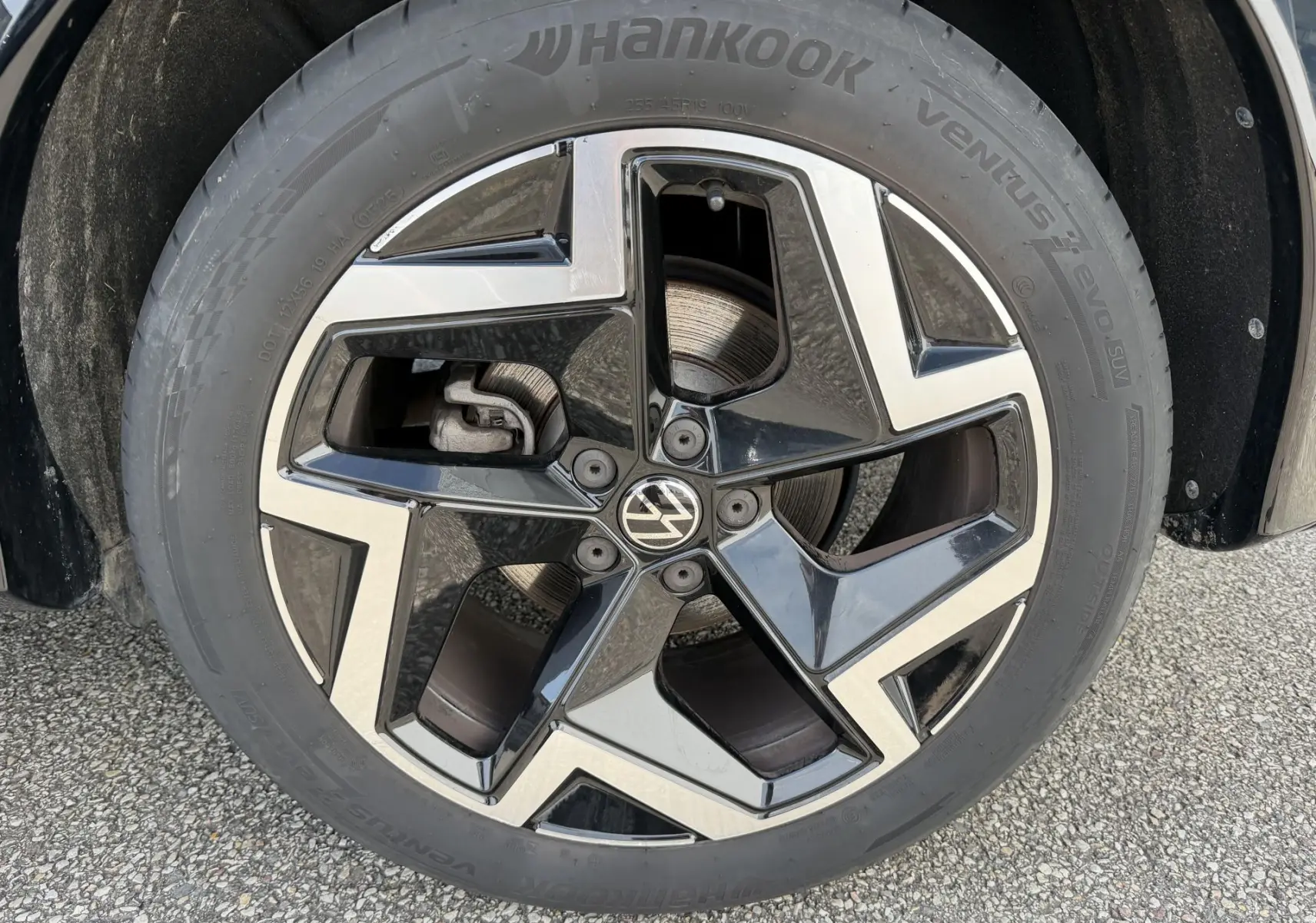 Gros plan sur la jante alliage 19 pouces noire et argentée du Volkswagen Tiguan 2.0 TDI 2025, avec logo VW central.