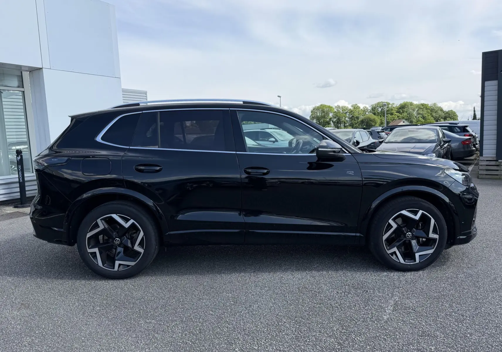 Vue latérale côté gauche du Volkswagen Tiguan noir avec jantes alliage 19 pouces au design distinctif R-Line.