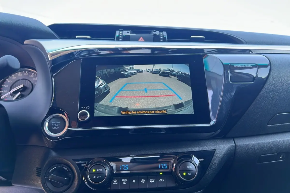 Vue rapprochée de l’écran central du Toyota Hilux 2026 montrant la caméra de recul et les commandes de climatisation.