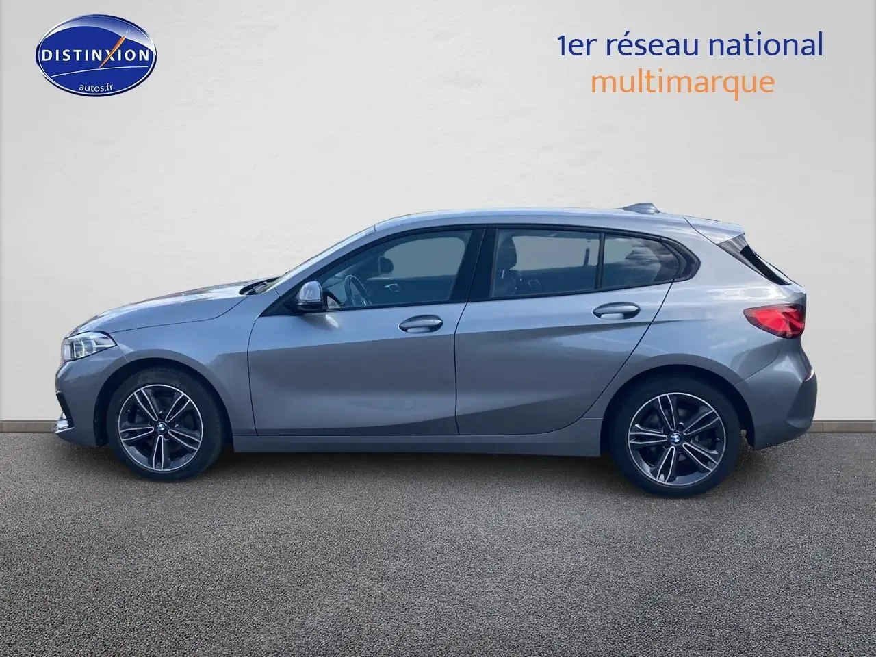 BMW Série 1 gris foncé vue de profil côté gauche, soulignant ses jantes alliage 17 pouces et lignes dynamiques.