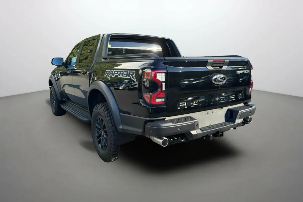 Ford Ranger Raptor noir absolu vu en 3/4 arrière droit, avec logo Raptor et double sortie d'échappement visible.
