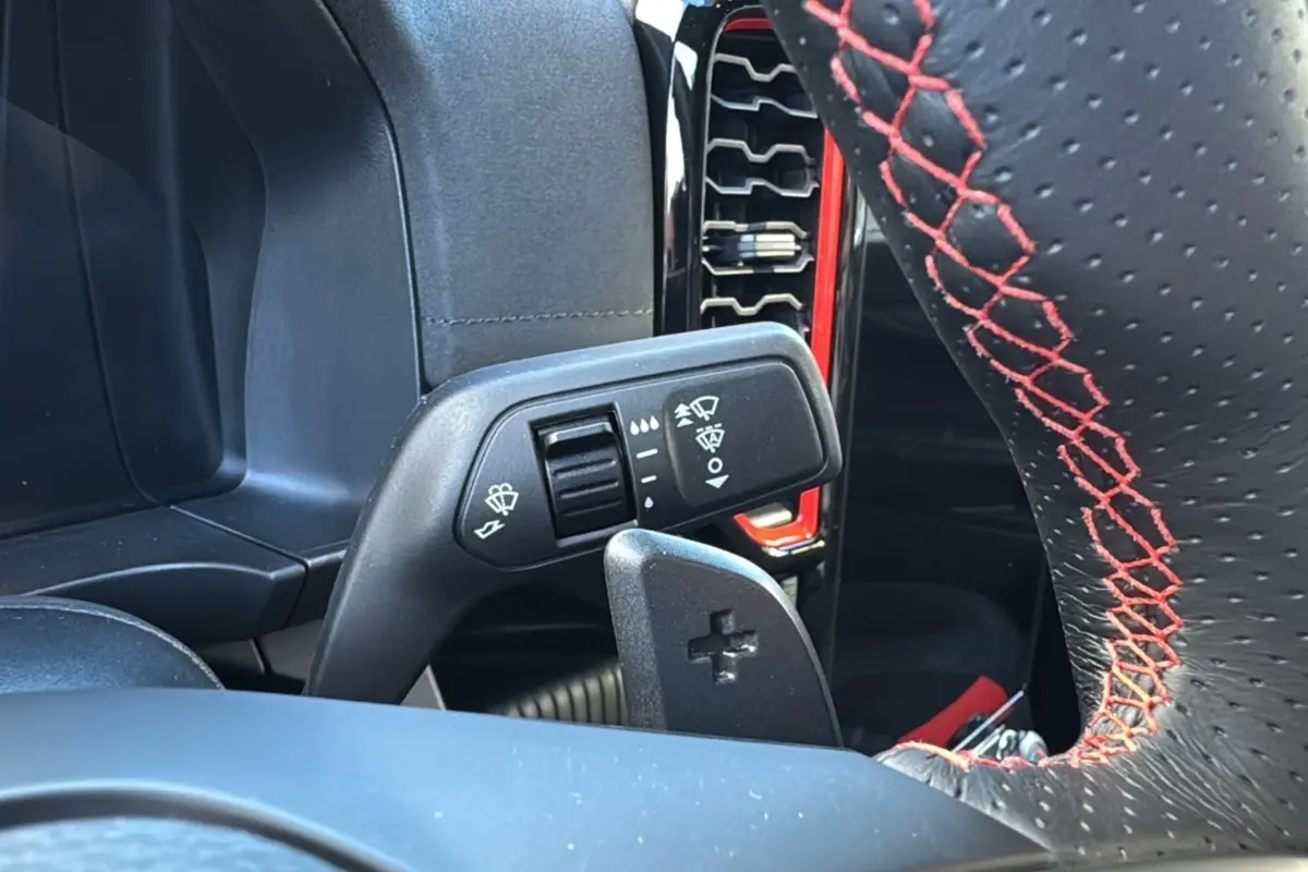 Gros plan sur la commande d'essuie-glace et le volant noir à surpiqûres rouges du Ford Ranger Raptor 2024.