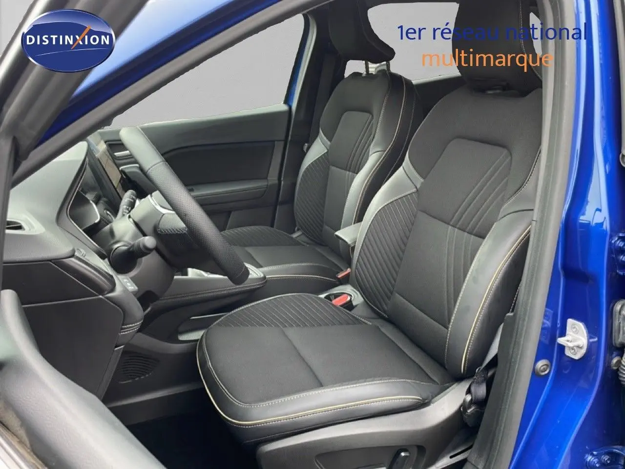 Vue intérieure côté gauche montrant les sièges avant noirs avec surpiqûres contrastantes sur une Renault Symbioz bleu iron metal.