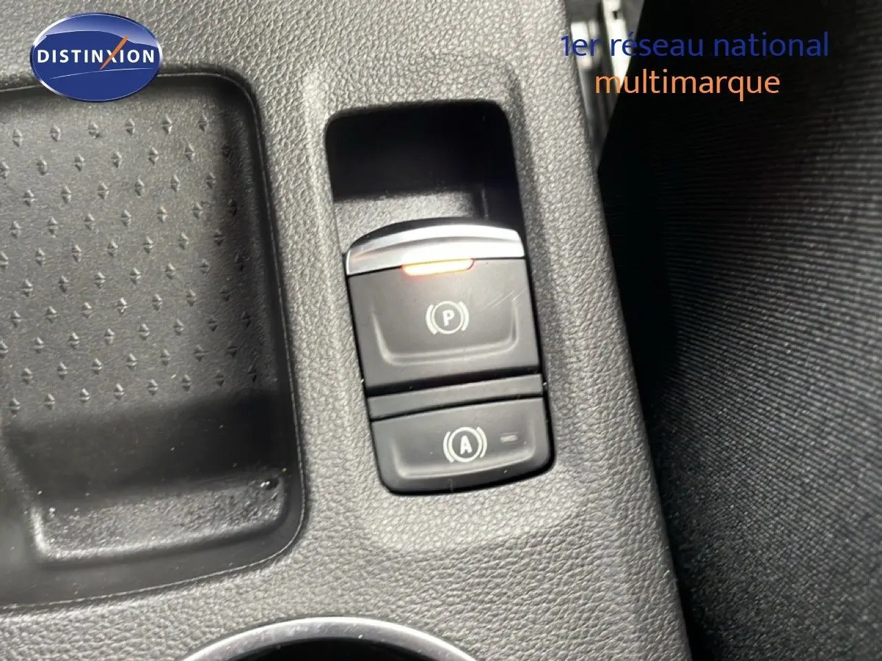 Gros plan sur les commandes de frein à main électronique et assistance au démarrage du Renault Symbioz bleu Iron Metal.