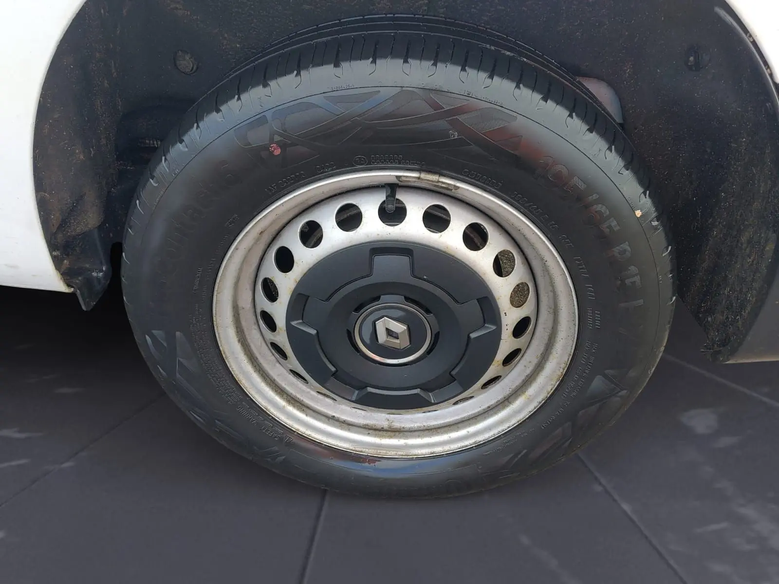 Gros plan sur la roue avant gauche blanche d’un Renault Kangoo 2022 avec jante acier et logo Renault central.