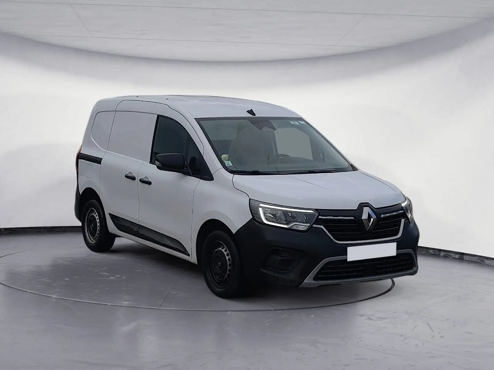 Renault Kangoo blanc en 3/4 avant droit, fourgonnette utilitaire avec pare-chocs noir et vitres teintées.
