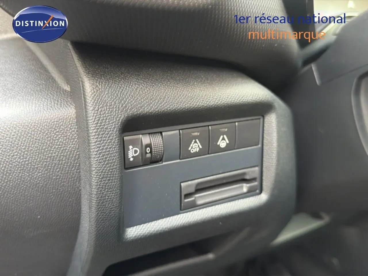 Détail des commandes de réglage des phares et aides à la conduite sur le tableau de bord noir du Citroën C5 Aircross gris platinium.