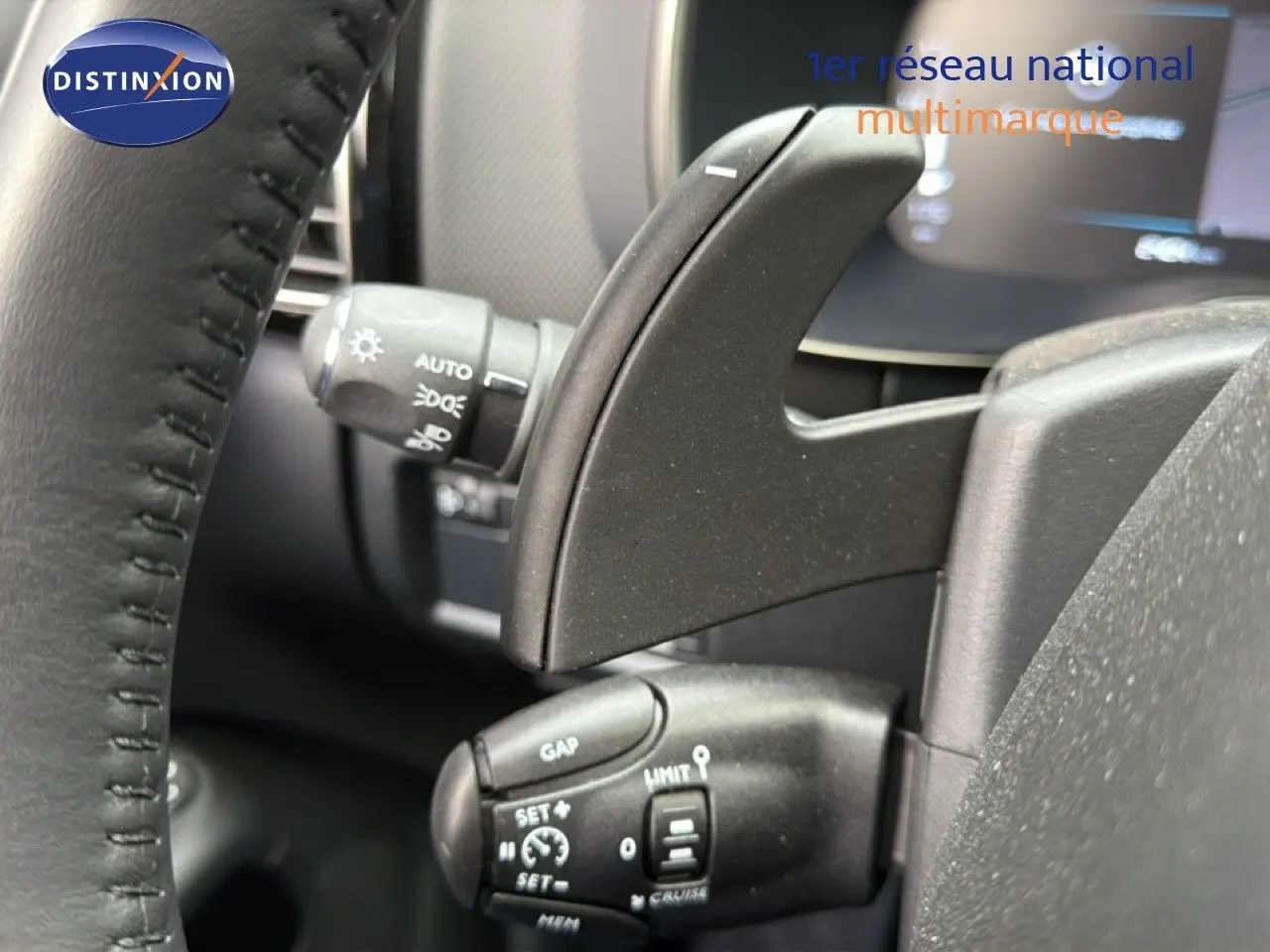 Gros plan sur les commandes au volant du Citroën C5 Aircross 2025, intérieur noir avec palettes de changement de vitesse.