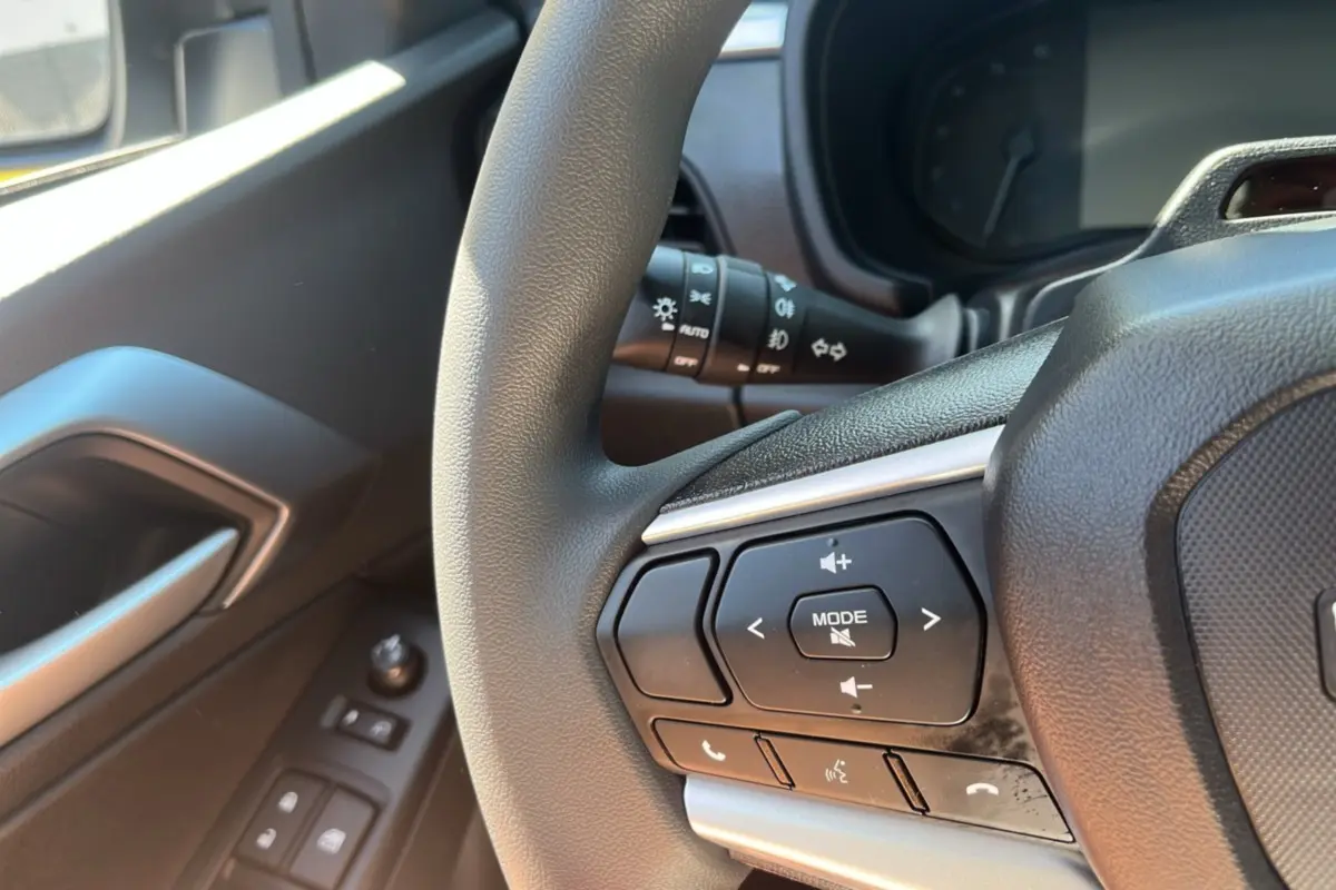 Gros plan sur le volant multifonctions noir et la portière côté gauche avec commandes électriques du Isuzu D-MAX 2026.