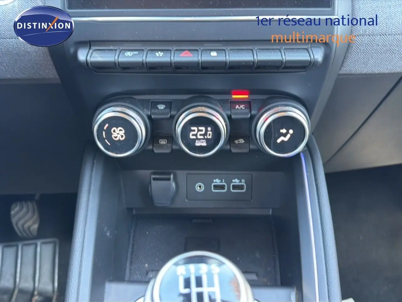 Gros plan sur la console centrale de la Renault Clio 2025, montrant la climatisation digitale et le levier de vitesses manuel.