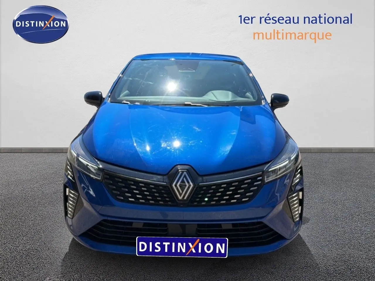 Vue frontale d'une Renault Clio 2025 bleu iron metal avec calandre noire et phares LED distinctifs.