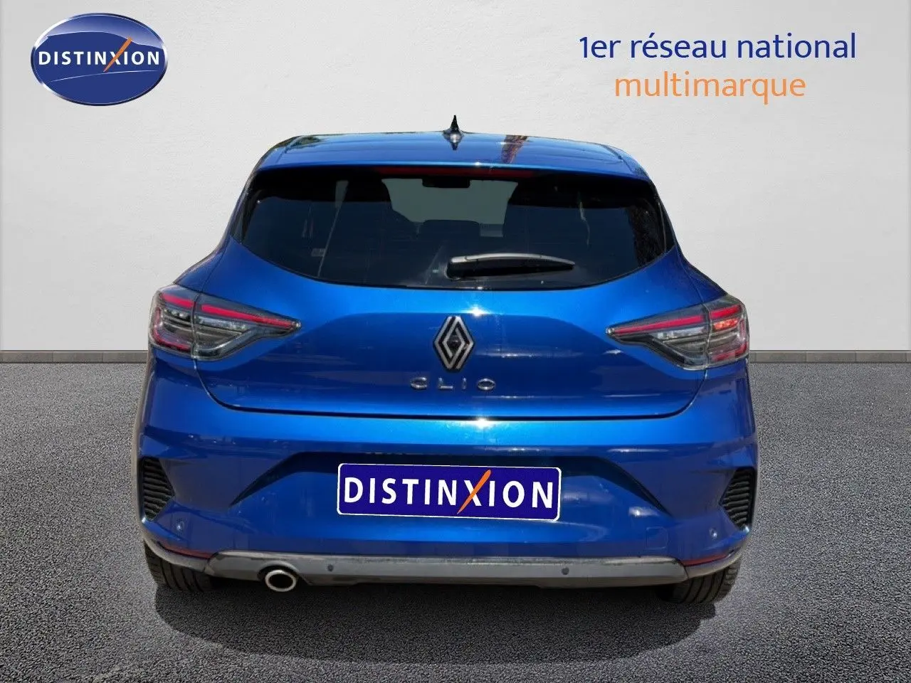 Vue arrière d'une Renault Clio bleu Iron Metal 2025 avec feux LED et sortie d'échappement visible côté gauche.
