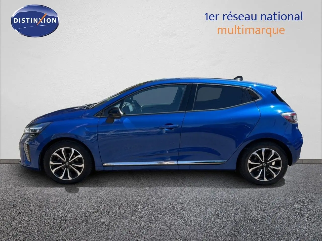 Profil droit d'une Renault Clio 2025 bleu iron metal avec jantes alliage et vitres teintées, sur fond clair neutre.