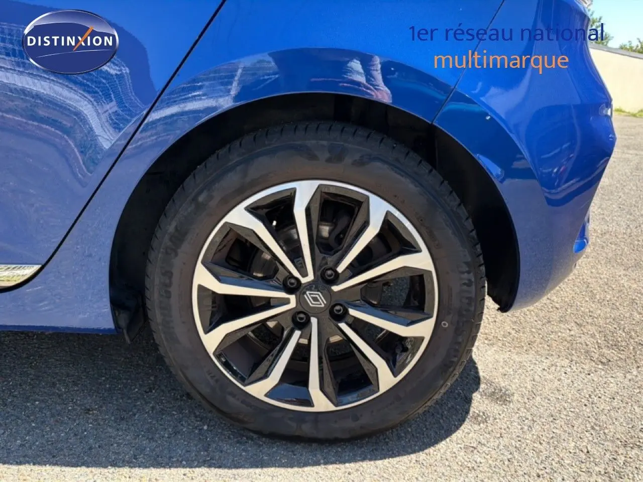Gros plan sur la roue arrière droite d'une Renault Clio bleu iron metal avec jante alliage 16 pouces design moderne.