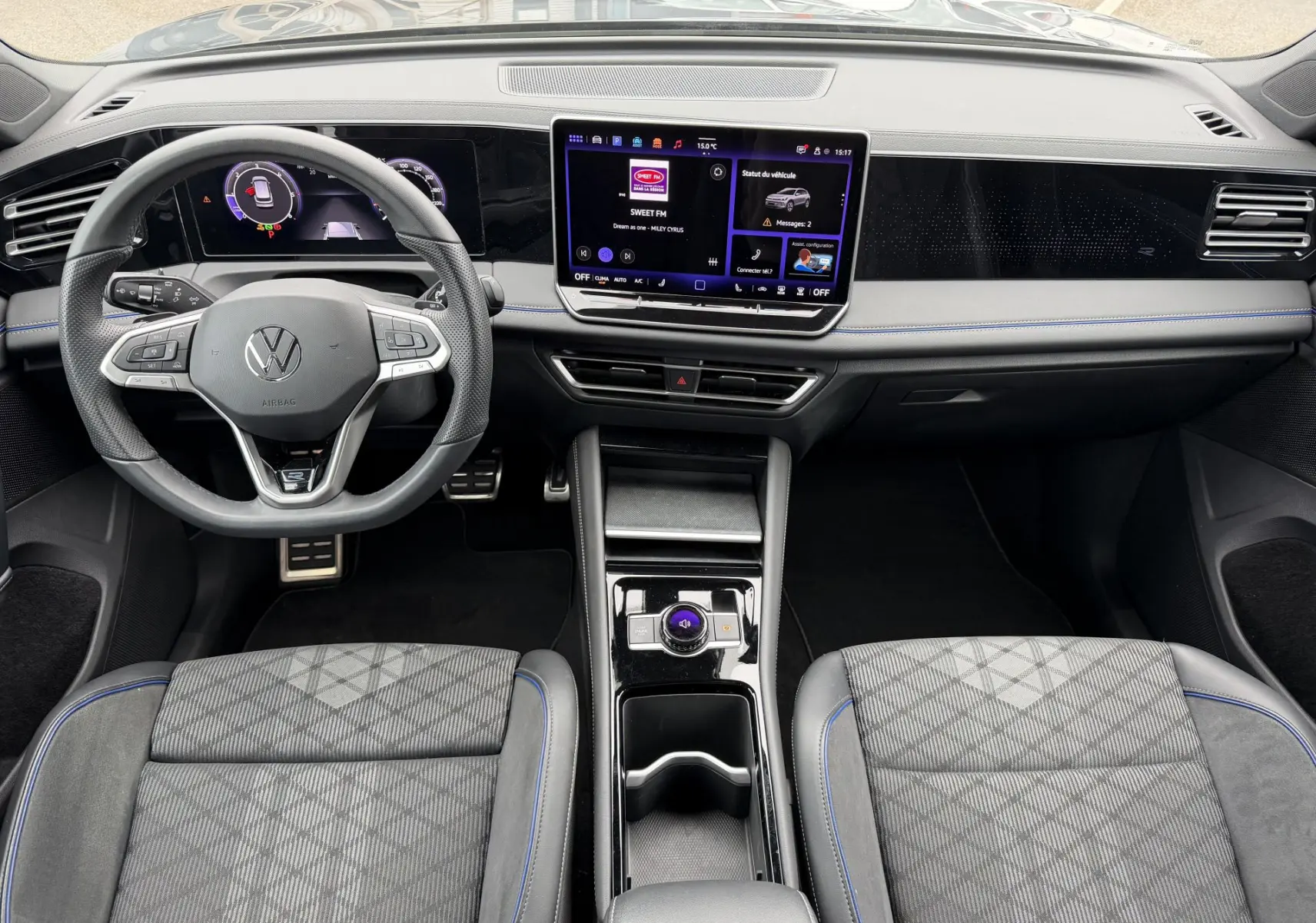 Vue intérieure du Volkswagen Tiguan 2025 montrant le tableau de bord noir avec écran tactile central et volant multifonction cuir.