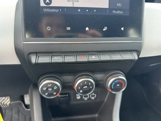 Vue rapprochée de la console centrale de la Renault Clio noire 2022, montrant les commandes de climatisation et l'écran tactile.