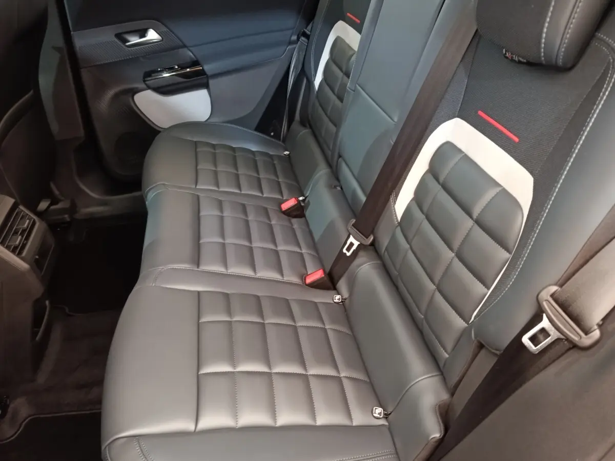 Vue intérieure du siège arrière droit en cuir noir et tissu gris clair du Citroën C5 Hybride 2026.