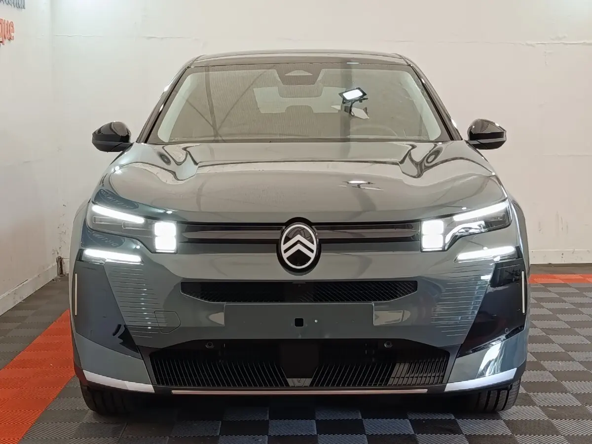 Vue frontale d'une Citroën C5 hybride 145ch auto MAX verte avec feux LED allumés et logo Citroën central.