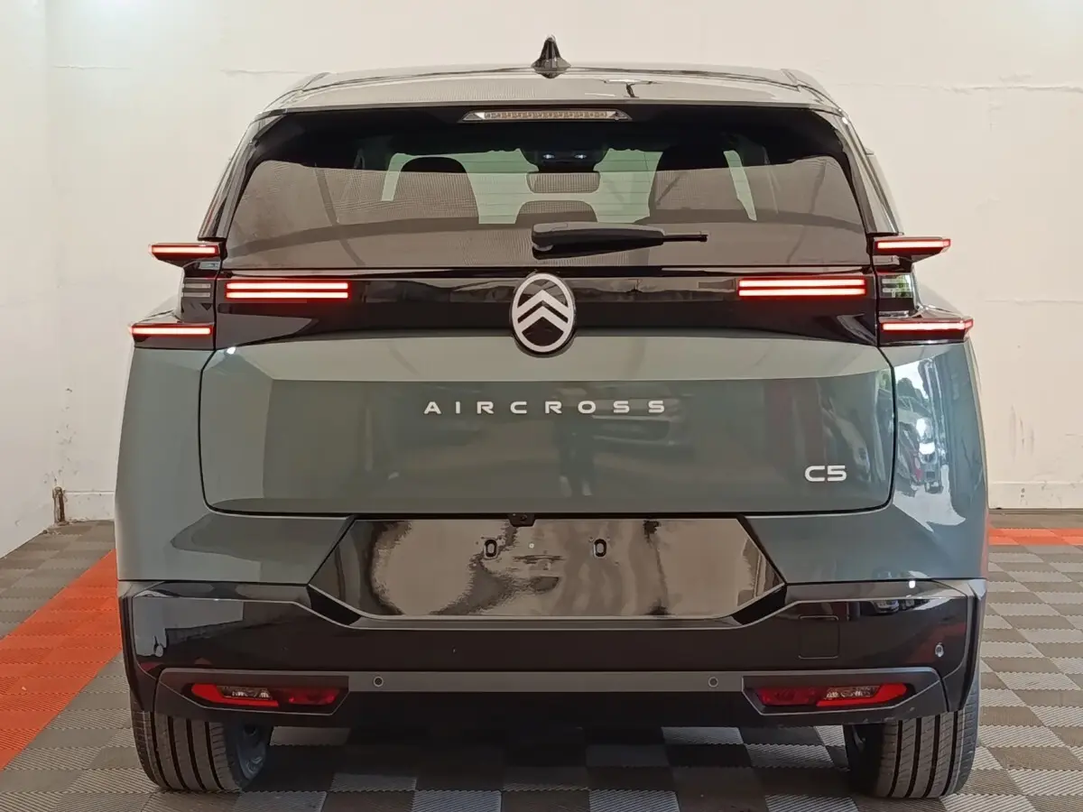 Vue arrière d'un Citroën C5 Aircross hybride vert avec feux arrière LED horizontaux et toit noir brillant.