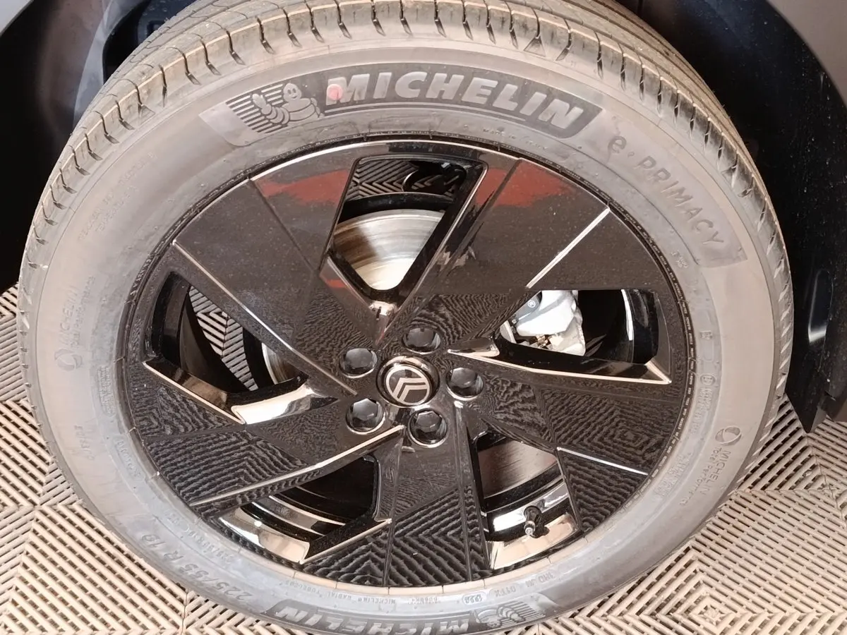 Gros plan sur la jante noire brillante de la Citroën C5 Hybride 2026 avec pneu Michelin visible.