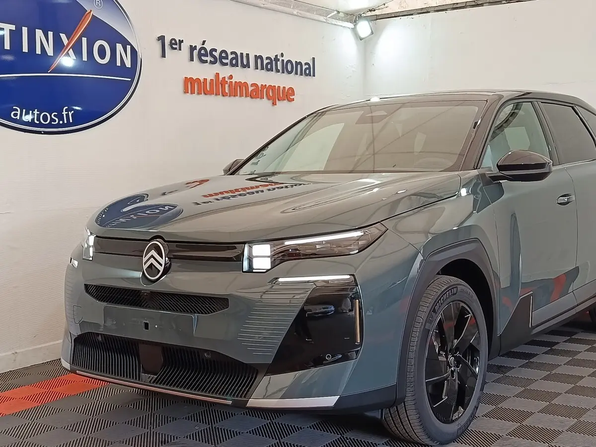 Vue 3/4 avant droit d'une Citroën C5 hybride verte avec calandre noire et jantes noires brillantes.