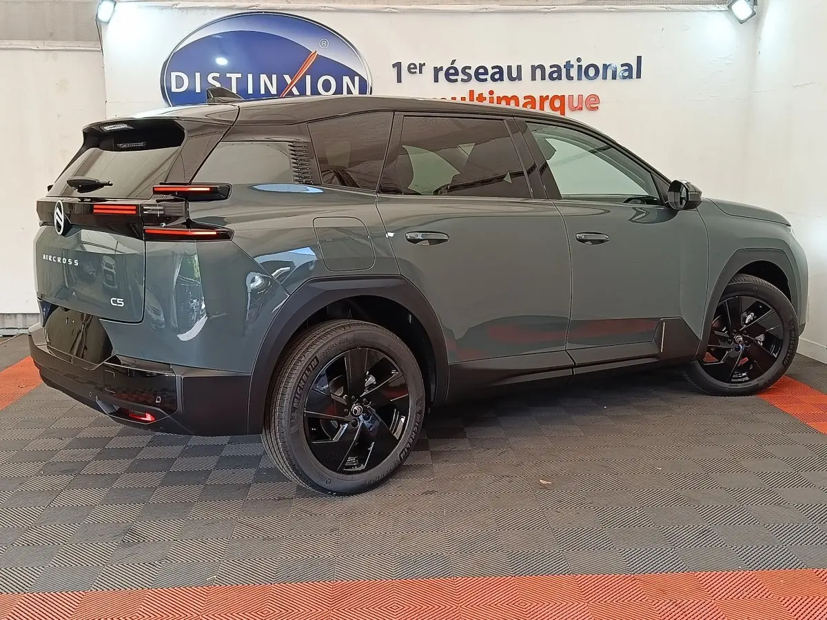 Vue 3/4 arrière droite d'un Citroën C5 Aircross hybride vert avec jantes noires et feux arrière LED distinctifs.