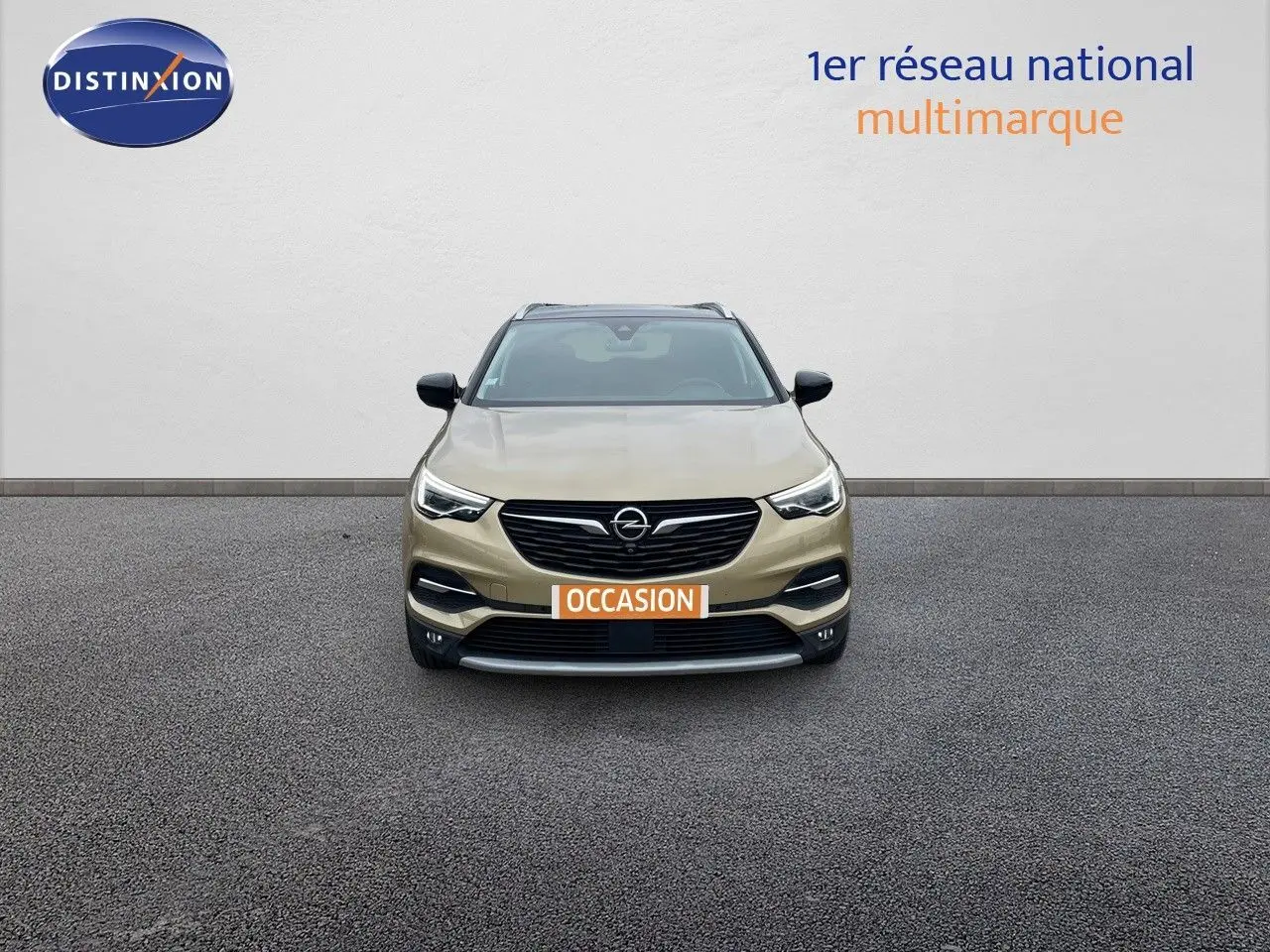 Vue frontale d'un Opel Grandland X 2018 couleur Golden Sunstone Metal avec plaque "OCCASION" sur un sol gris.