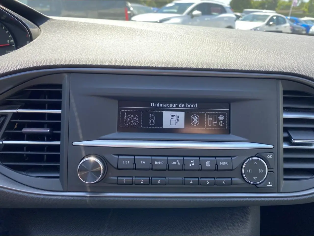 Tableau de bord de Peugeot 308 SW 2017 avec écran ordinateur de bord et commandes audio visibles en gros plan.