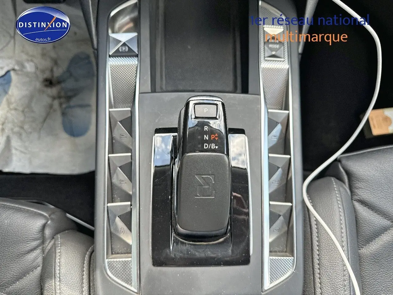 Gros plan sur la console centrale du DS3 Crossback E-TENSE 2021, avec levier de vitesses automatique et cuir noir.