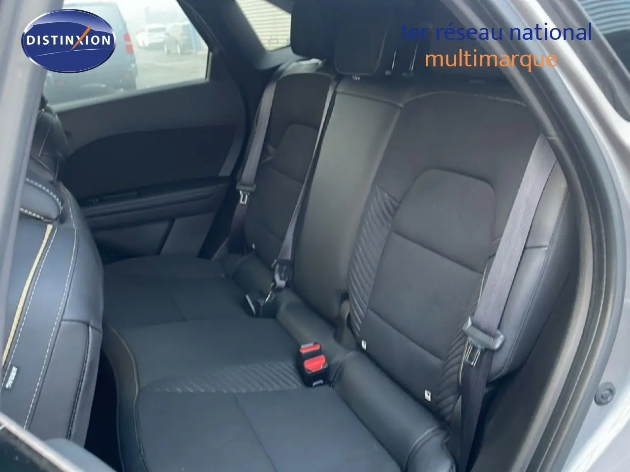 Vue intérieure arrière côté droit montrant les sièges en tissu noir avec surpiqûres contrastantes du Renault Symbioz gris cassiopée métal.