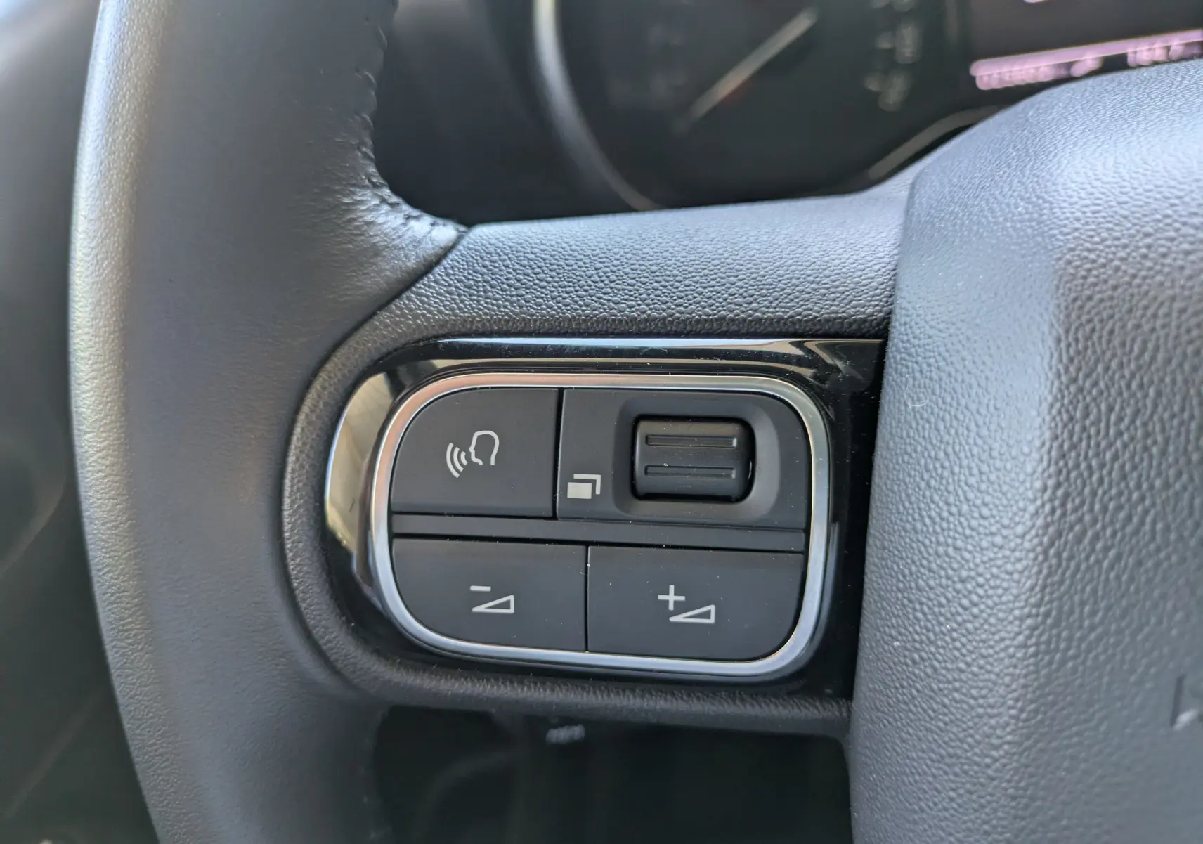 Gros plan sur la commande de régulateur de vitesse au volant d'une Citroën C3 Aircross 2024 gris Artense.