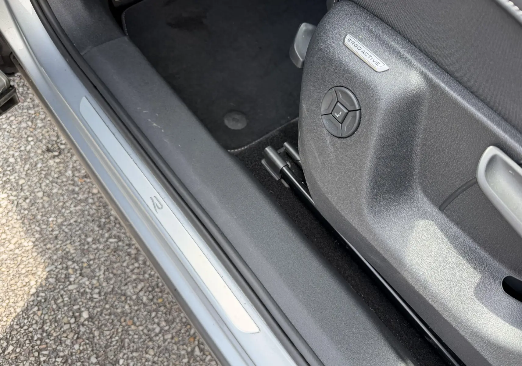 Détail de la porte côté gauche d’un Volkswagen Tiguan gris, avec siège ErgoActive et seuil de porte R-Line.