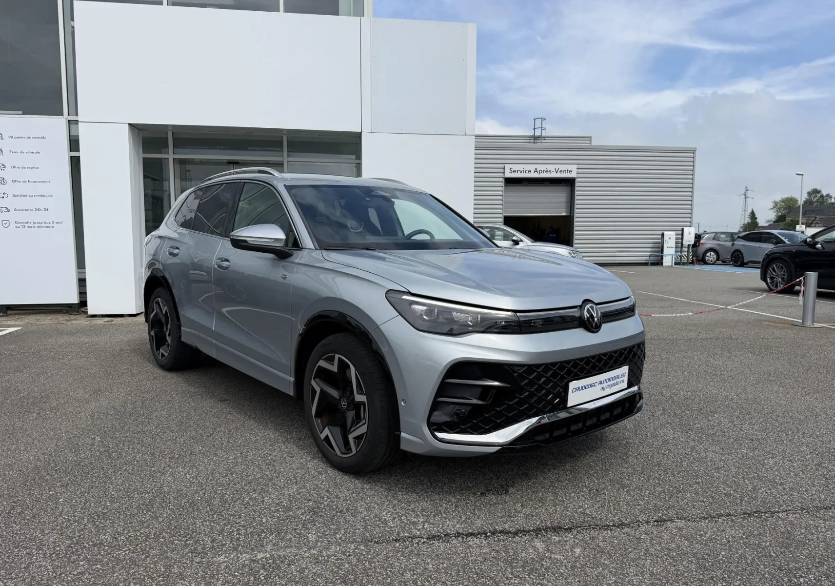Volkswagen Tiguan gris en 3/4 avant droit, avec jantes noires et calandre au design sportif R-Line.