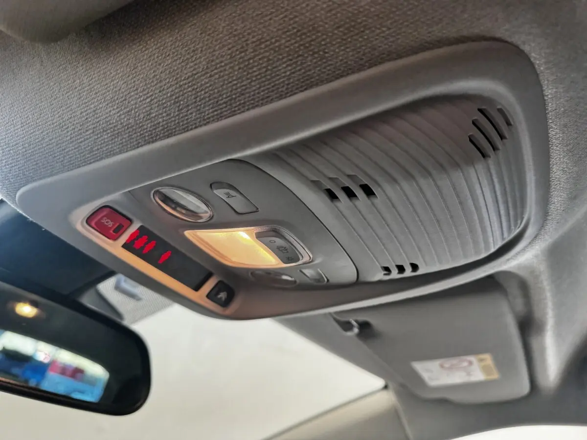 Vue intérieure en contre-plongée du plafonnier gris avec éclairage et boutons SOS dans une Citroën C3 gris foncé de 2019.